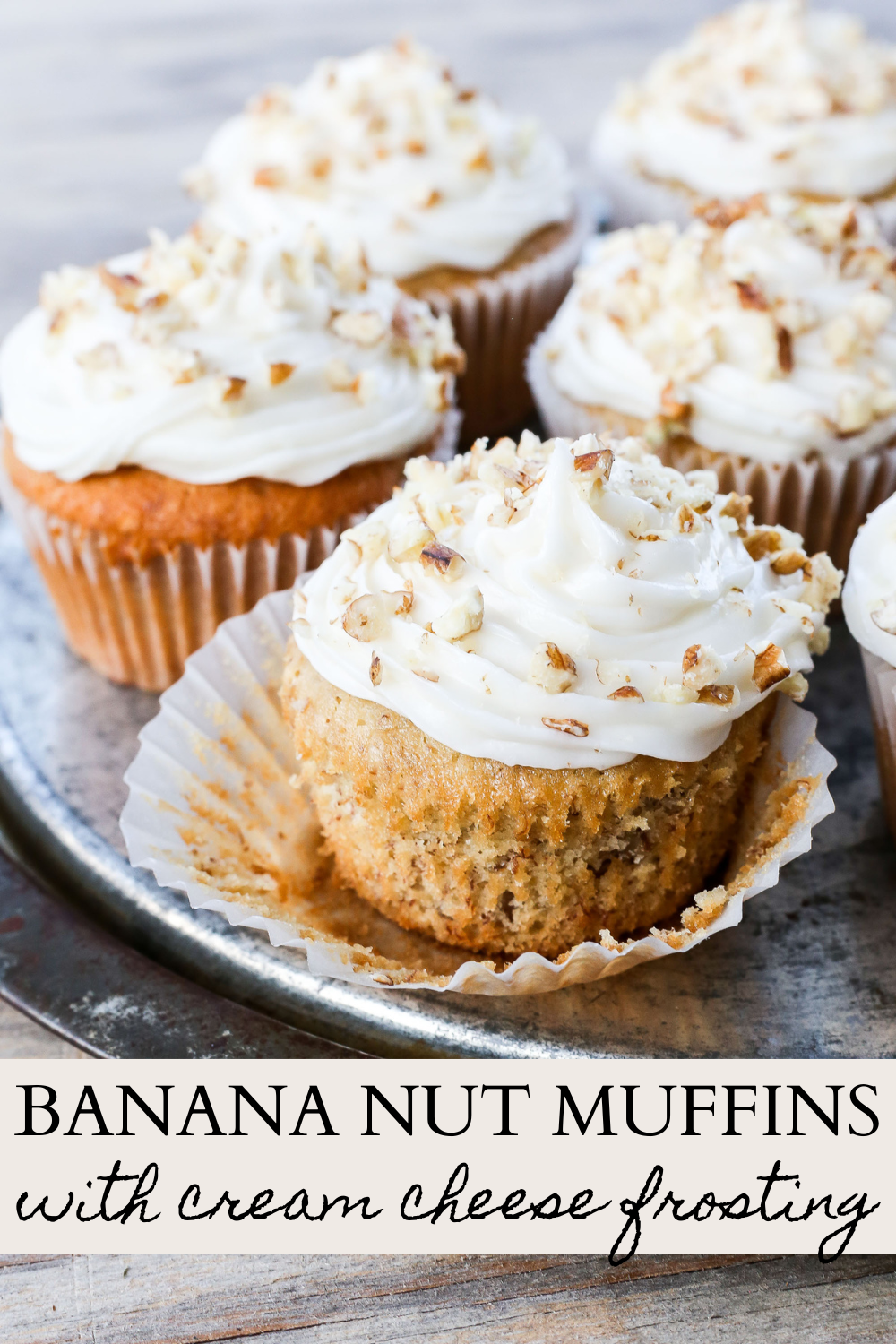 Banana nut muffins with cream cheese frosting on showcased on a plate.