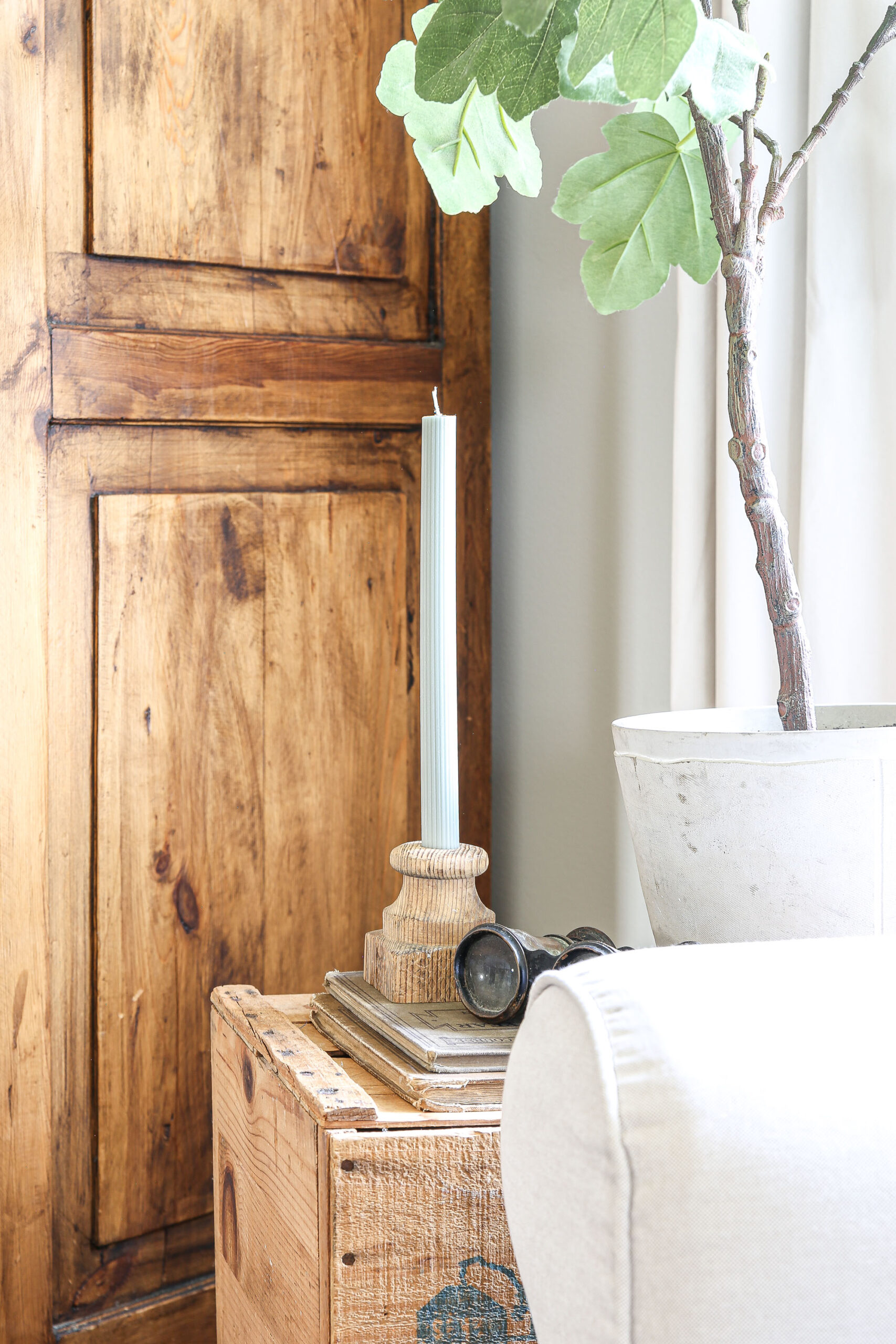 Beautiful ribbed olive green taper candle in antique wood candle holder.